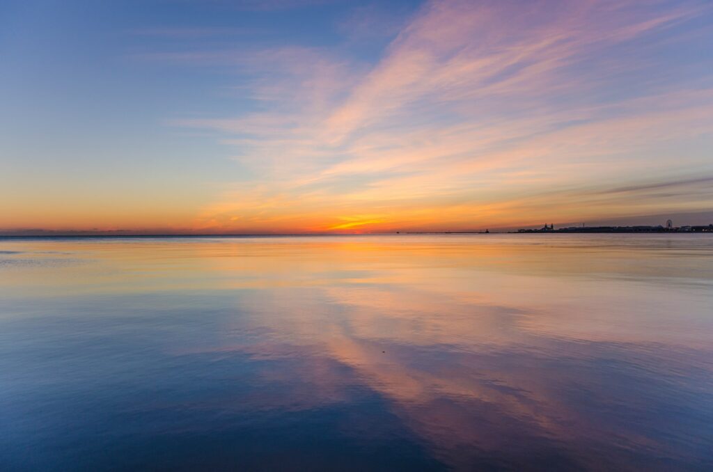 Beautiful calming sunrise over water with hues of blues