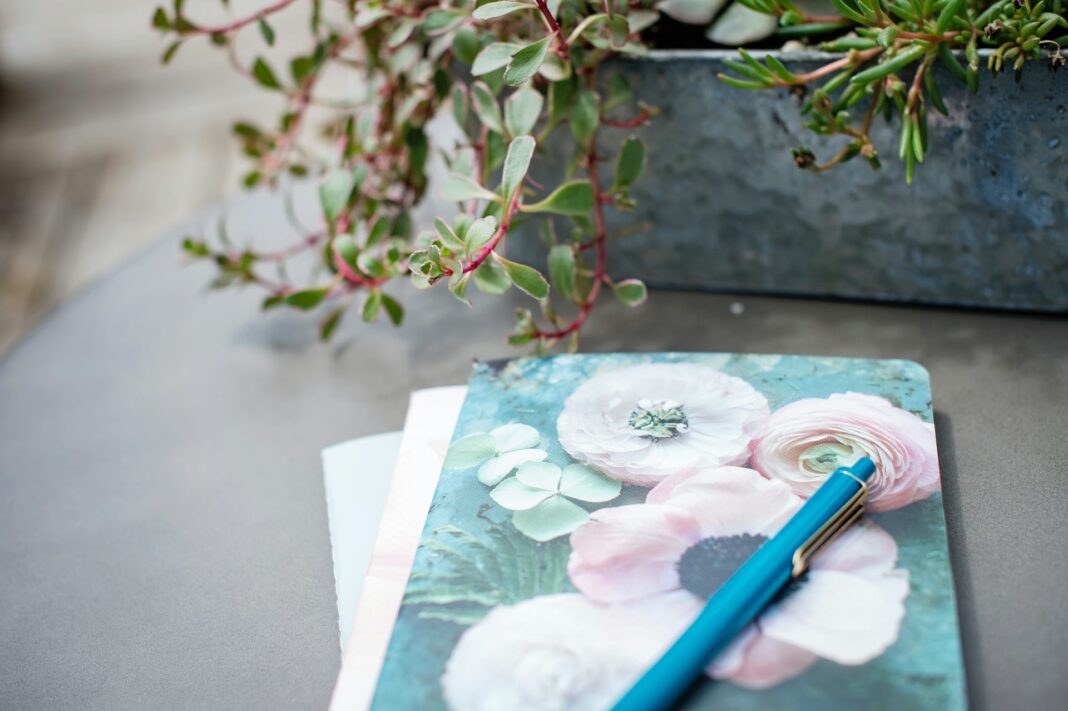 Sweet journal with flowers on it and a plant nearby
